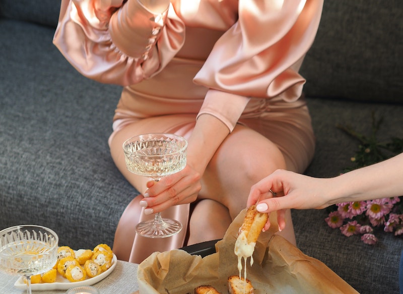 Female Drinking Champagne in Pink Satin Dress